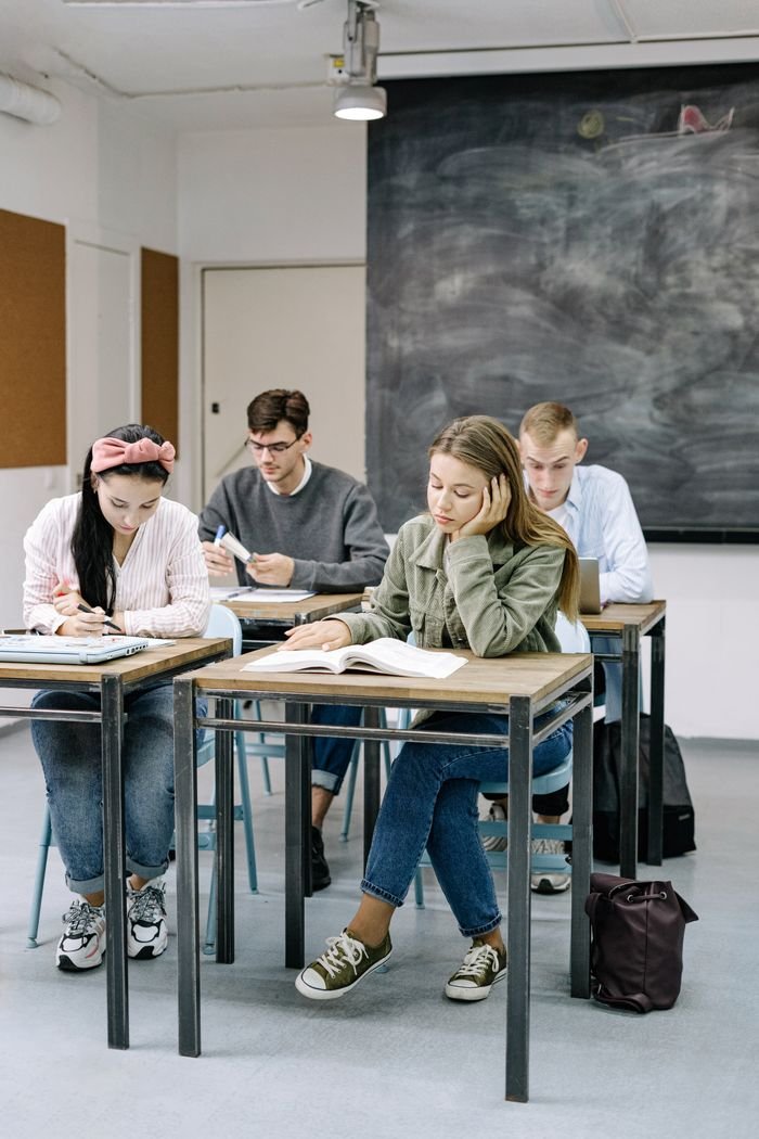 about-us-02 A group of teenagers focusing on studies in a classroom with a blackboard.